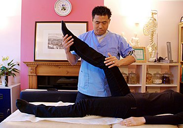 Taegyun Kim performing a kinesiology muscle test